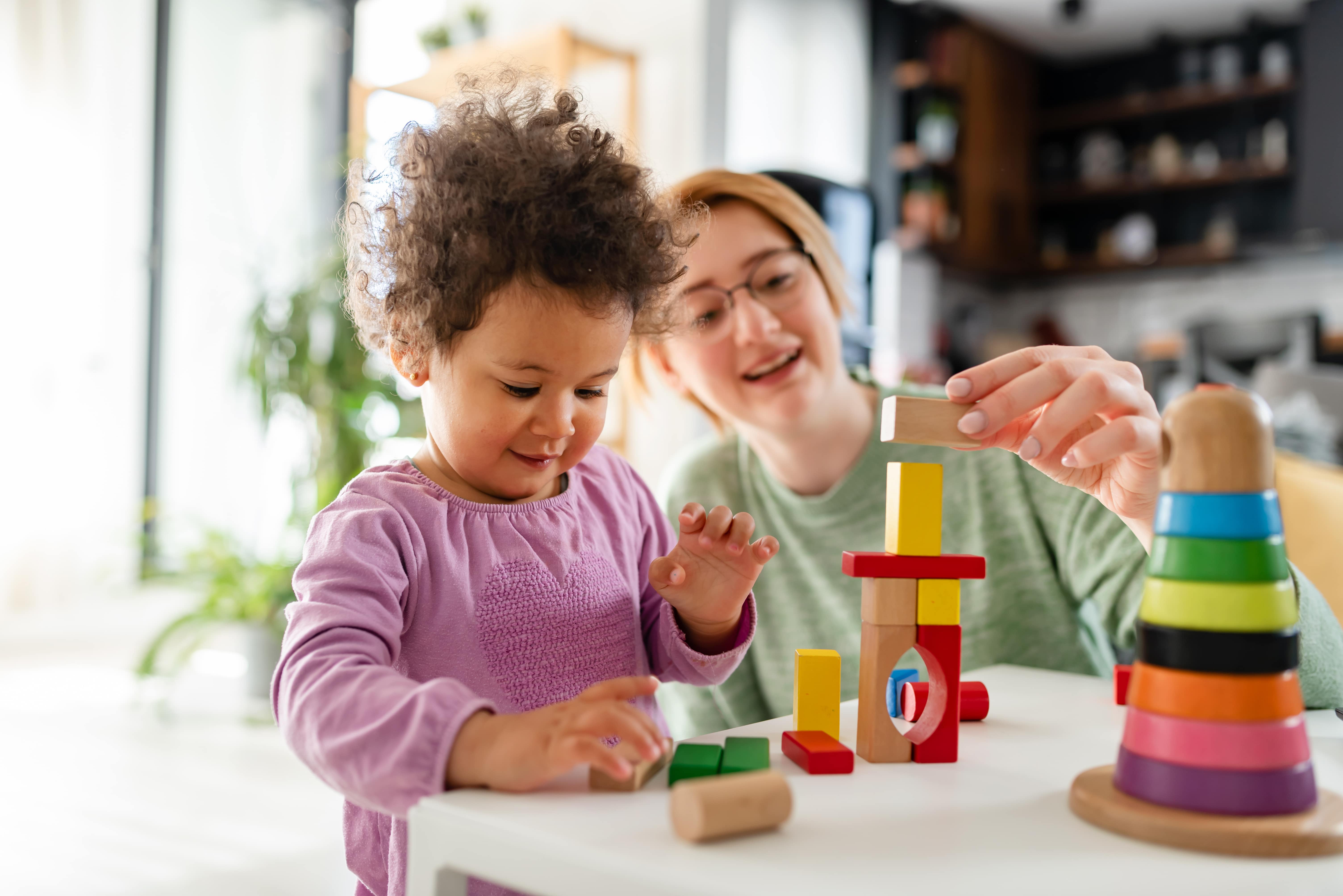 Mother and Daughter Playing Together with Didactic Toys