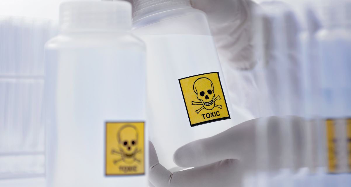Scientist Holding Bottle with Toxic Label