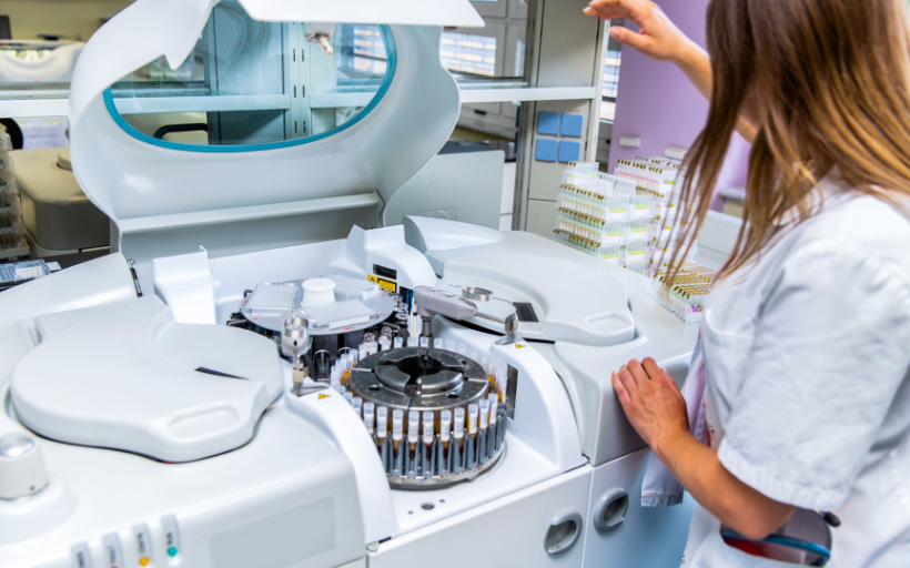 Lab scientist placing test tubes with blood samples in centrifuge